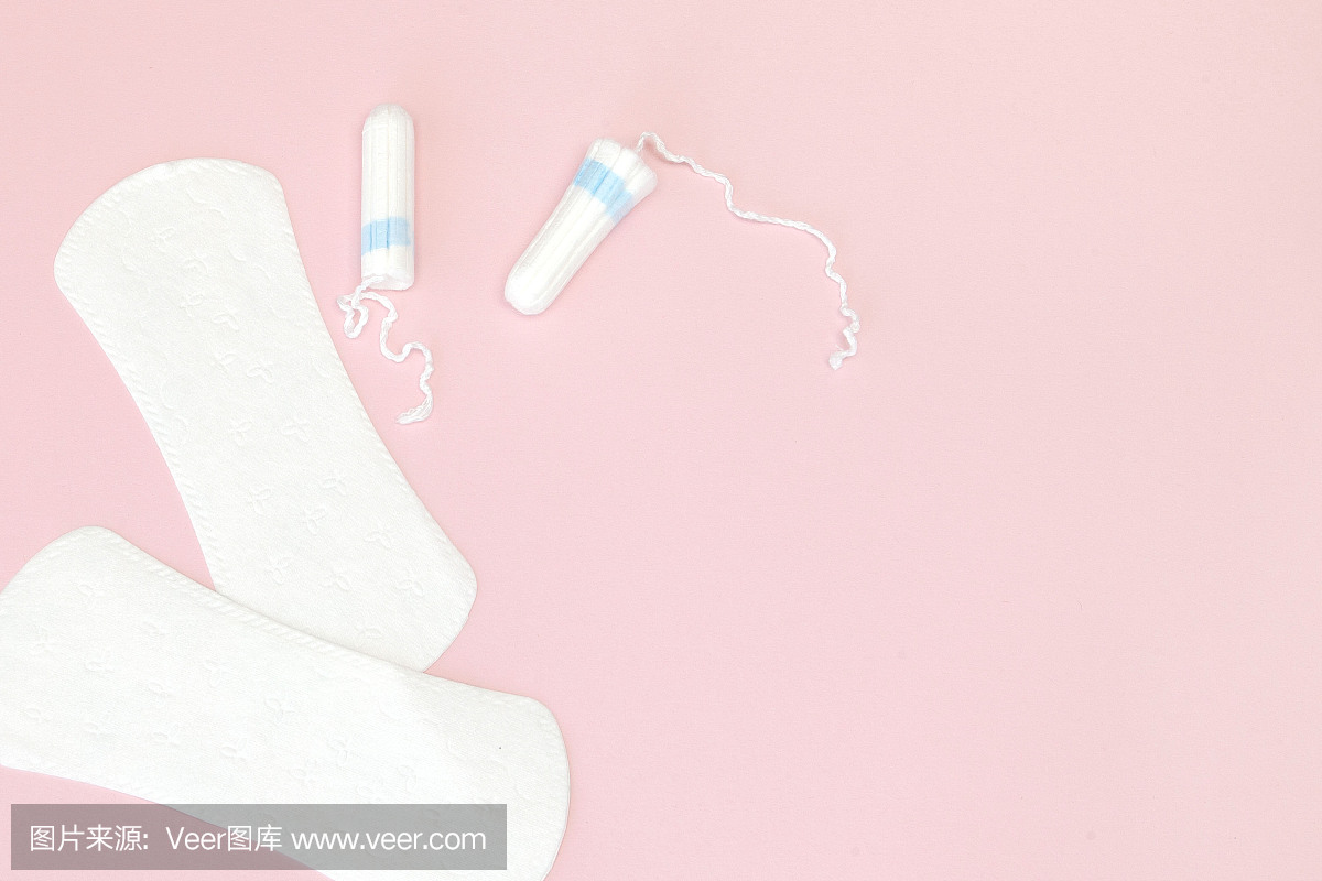 女性私密卫生用品——粉色背景的卫生巾和卫生棉条,拷贝空间。月经期的概念。俯视图,平放,复制空间